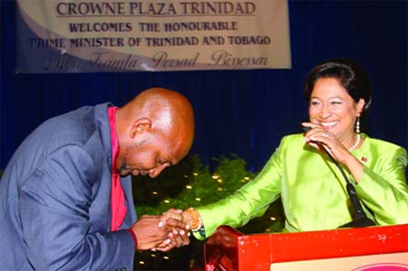 Photo: Ex-Sport Minister Anil Roberts (left) pays his respects to then Prime Minister Kamla Persad-Bissessar.