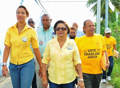 Photo: Then Prime Minister Kamla Persad-Bissessar (centre) and candidate Khadijah Ameen (left) walk-about during the UNC's unsuccessful by-election campaign in Chaguanas West. (Courtesy Jyoti Communications)