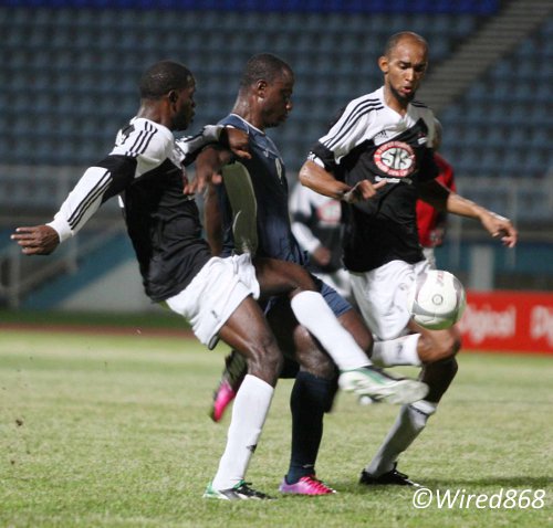 Photo: Defence Force forward Richard Roy (centre) tries to burst past Central FC defenders Keion Goodridge (left) and Akeem Benjamin. (Courtesy Wired868)