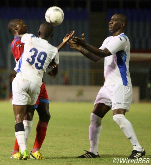 Photo: Police midfielders Trent Noel (right) and Joel Lewis (number 39) try to wrestle the ball from St Ann's Rangers attacker Kennedy Isles during the 2013/14 Pro League season. (Courtesy Wired868)