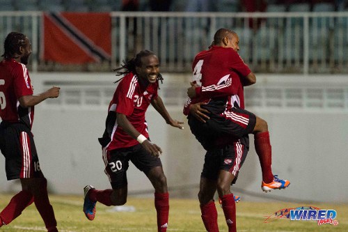 Photo: Trinidad and Tobago defender Seon Power (second from left) and midfielder Keyon Edwards (far left) celebrate with their teammates during the 2012 Caribbean Cup finals in Antigua. (Courtesy Allan V Crane/Wired868)