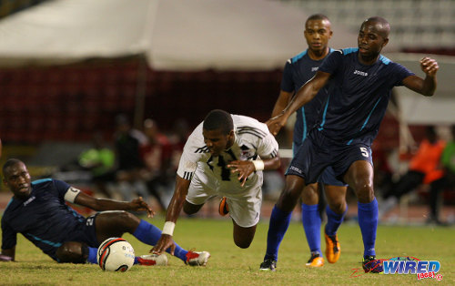 Photo: Former Central FC forward Dwight Quintero (centre) goes down under a challenge from Police captain Todd Ryan (far left) while Anton Hutchinson (far right) and Kenaz Williams look on during a 2013/14 Pro League contest. (Courtesy Allan V Crane/Wired868)