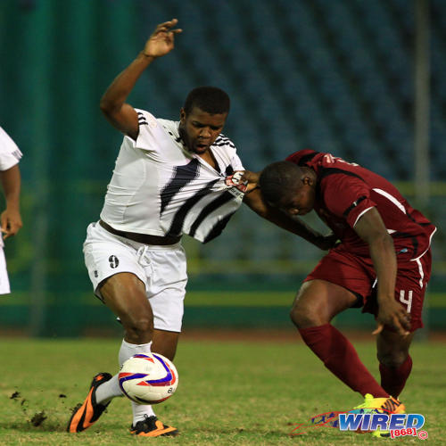 Photo: Former Central FC forward Dwight Quintero (left) tries to escape from North East Stars midfielder Keithy Simpson during a 2013/14 Pro League contest. (Courtesy Allan V Crane/Wired868)