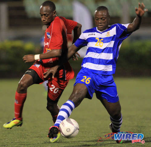 Photo: Defence Force forward Richard Roy (right) holds off Caledonia AIA utility player Noel Williams in a previous clash. Roy scored twice against St Ann's Rangers tonight. (Courtesy Allan V Crane/Wired868)