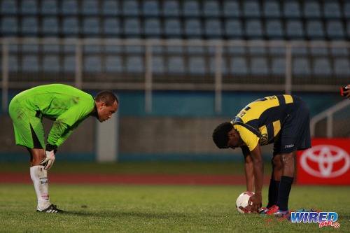 Photo: Caledonia AIA goalkeeper Shemel Louison (left) faces Club Sando attacker Devon Modeste during the 2013 Toyota Classic competition. (Courtesy Allan V Crane/Wired868)