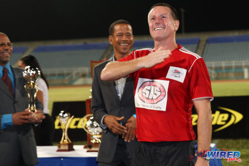 Photo: Terry Fenwick (right) salutes the crowd after leading Central FC to the 2014 Lucozade Sport Goal Shield title. Looking on is Pro League CEO Dexter Skeene (centre). (Courtesy Allan V Crane/Wired868)