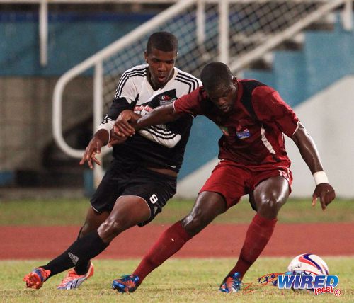 Photo: Ex-Central FC forward Dwight Quintero (left) tries to slow down North East Stars defender Glenton Wolfe during 2013/14 Pro League action. (Courtesy Allan V Crane/Wired868)