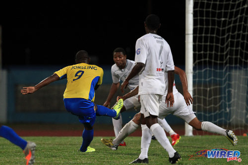 Photo: Defence Force striker Devorn Jorsling (left) fires past a crowd of W Connection defenders during the 2013/14 Pro League season. (Courtesy Allan V Crane/Wired868)