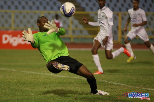 Photo: Police FC goalkeeper Adrian Foncette makes a point blank save from W Connection left back Kurt Frederick (not in photo) during 2013/14 Pro League action. (Courtesy Allan V Crane/Wired868)