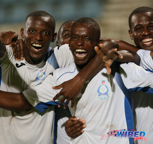 Photo: Police FC brothers Jameel (left) and Kareem Perry (centre) celebrate during a Pro League knock out affair in the 2013/14 season. (Courtesy Allan V Crane/Wired868)