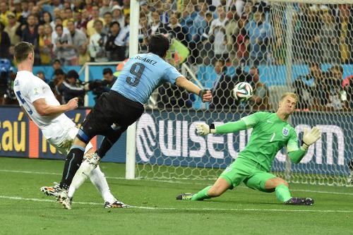 Photo: Uruguay forward Luis Suarez (centre) blasts the ball past England goalkeeper Joe Hart (right) while defender Tim Cahill watches on during the Brazil 2014 World Cup. (Copyright AFP 2014/Luis Acosta)