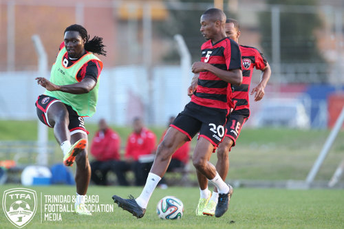 Photo: Trinidad and Tobago captain Kenwyne Jones (left) drives a shot past teammate Kevan George (centre) during a training session in Buenos Aires in June 2014. (Courtesy Allan V Crane/TTFA Media)