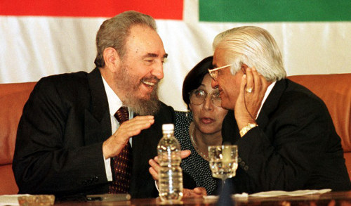 Photo: Former Trinidad and Tobago prime minister Basdeo Panday (right) shares a joke with then Cuba president Fidel Castro during the closing ceremony of a CARIFORUM meeting in 1998.   (Copyright AFP 2014/Roberto SCchmidt)