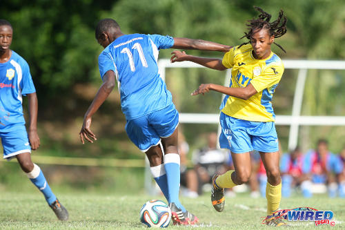 Photo: Shiva Boys midfielder Tyrel "Pappy" Emmanuel (right) dribbles past Presentation College (San Fernando) midfielder Kareem Riley during 2014 SSFL action. (Courtesy Allan V Crane/Wired868)