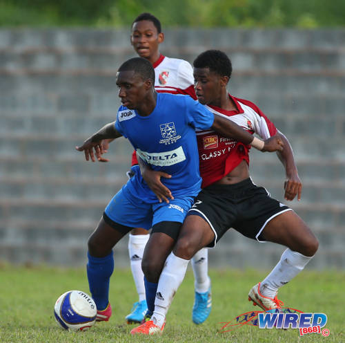 Photo: Trinity College East striker Dareem Daniel (left) holds off St Anthony's College right back Jared Flement (right) during a 2015 SSFL Premier Division fixture. (Courtesy Allan V Crane/Wired868)