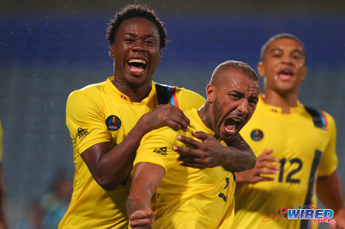 Photo: Antigua and Barbuda midfielder Joshua Parker (centre) celebrates with teammates Quinton Griffith (left) and Nathaniel Jarvis during the 2014 Caribbean Cup qualifiers. Parker, Griffith and Jarvis play professionally in the United States, Slovakia and England respectively. (Courtesy Allan V Crane/Wired868)