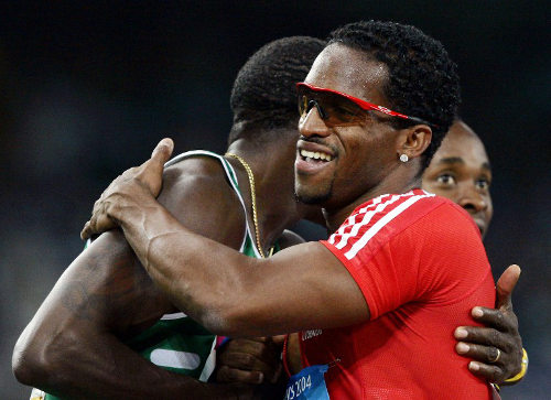 Photo: Trinidad and Tobago former Olympic star Ato Boldon (right) hugs an unidentified Nigerian sprinter during his track hey-day. (Copyright AFP 2014/Jeff Haynes)