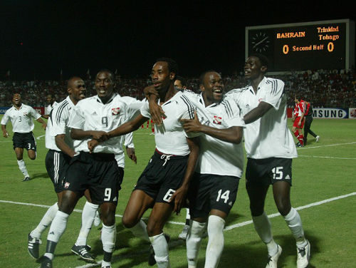 Photo: Stern John (second from right) celebrates with goal scorer Dennis Lawrence (centre), Kenwyne Jones (far right), Aurtis Whitley (second from left) and Cyd Gray after going ahead against Bahrain in a famous 2006 World Cup playoff contest on 16 November 2005. (Copyright AFP 2014)