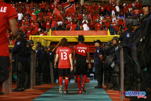 Photo: Trinidad and Tobago players Kennya Cordner (right) and Anique Walker head for the dressing room after their 1-0 FIFA 2015 Women's Cup Play Off second leg defeat to Ecuador on 2 December 2014 in Port of Spain. (Courtesy Allan V Crane/Wired868)