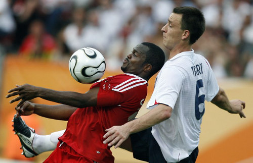 Photo: Trinidad and Tobago's record goal scorer Stern John (left) controls the ball under pressure from England's John Terry at the 2006 World Cup. (Copyright AFP 2015)