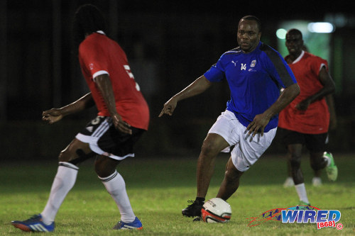 Photo: Trinidad and Tobago's record goal scorer Stern John (right) runs at former 2006 World Cup teammate Brent Sancho during the 2014 Wired Football Festival. (Courtesy Allan V Crane/Wired868)