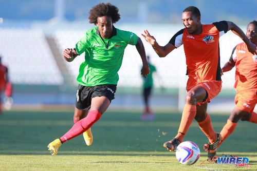 Photo: San Juan Jabloteh attacker Tyrone Charles (left) takes on Club Sando defender Andre Phillip during 2015 TTFA FA Trophy quarterfinal action in Malabar. (Courtesy Allan V Crane/Wired868)