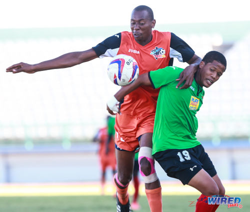 Photo: Club Sando striker Kevon Woodley (left) battles for the ball with San Juan Jabloteh defender Dillon Kirton during the 2015 TTFA FA Trophy quarterfinal in Malabar. (Courtesy Allan V Crane/Wired868)