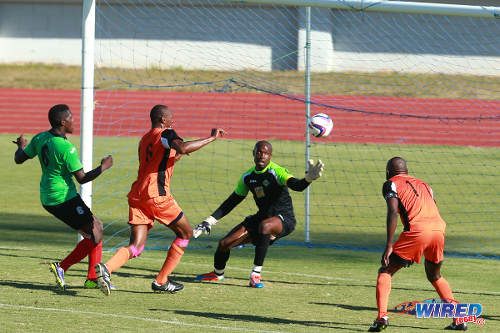 Photo: Club Sando striker Kevon Woodley (centre) bundles the ball past San Juan Jabloteh goalkeeper Shane Mattis (second from right) in the TTFA FA Trophy quarterfinals in Malabar. (Courtesy Allan V Crane/Wired868)