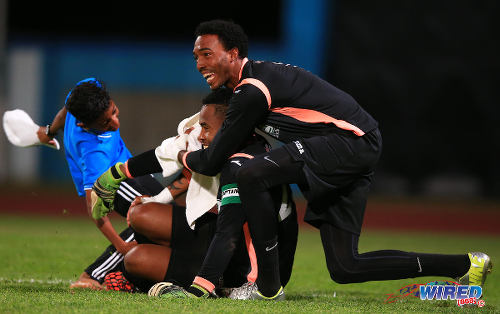 Photo: Then North East Stars hero Cleon John (centre) is congratulated by reserve goalie Stefan Berkeley after the 2015 TTFA FA Trophy final. (Courtesy Allan V Crane/Wired868)