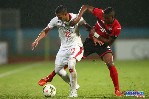 Photo: Trinidad and Tobago defender Sheldon Bateau (right) tries to wrestle the ball from Panama attacker Rolando Escobar during a friendly international at the Ato Boldon Stadium, Couva in March 2015. (Courtesy Allan V Crane/Wired868)