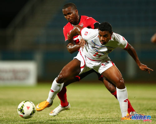 Photo: Trinidad and Tobago stand-in captain Khaleem Hyland (background) tries to muscle Panama midfielder Ricardo Buitrago off the ball in friendly action at the Ato Boldon Stadium, Couva in March 2015. (Courtesy Allan V Crane/Wired868)