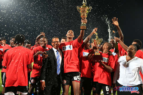 Photo: Central FC star Ataulla Guerra (centre) takes the 2014/15 Pro League trophy from Pro League CEO Dexter Skeene. (Courtesy Allan V Crane/Wired868)