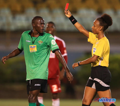 Photo: Referee Crystal Sobers (right) ejects San Juan Jabloteh midfielder Fabian Reid for dissent. (Courtesy Allan V Crane/Wired868)