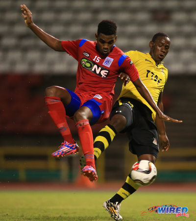 Photo: Defence Force striker Devorn Jorsling (right) holds off St Ann's Rangers defender Seon Thomas during 2014/15 Pro League action. (Courtesy Allan V Crane/Wired868)