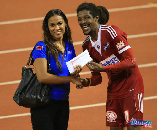 Photo: Central FC Marvin Oliver (right) is presented with a Ruby Tuesday gift certificate as Wired868's 2014/15 Player of the Year by Wired868 director of operations Lou-Ann Sankar. North East Stars midfielder Neveal Hackshaw was also honoured as Wired868's Young Player of the Year. (Courtesy Allan V Crane/Wired868)