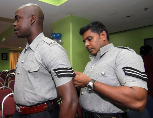 Photo: A police officer helps his colleague with his stripes.