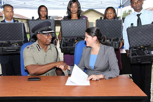 Photo: Acting Police Commissioner Stephen Williams (left) shakes hands with US Embassy Security Policy and Assistance Coordinator, Juanita Aguirre, at the handing over ceremony of 18 forensic photography kits to the Trinidad and Tobago Police Service by the US in 2015. (Courtesy US Embassy)