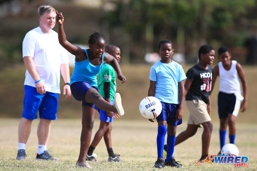 Photo: Former Chelsea midfielder Gareth Hall (background) offers shooting tips for children during a Tobago Legends training camp in Speyside, Tobago. (Courtesy Allan V Crane/Wired868)