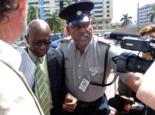 Photo: Former Chaguanas West MP and ex-FIFA vice president and TTFA special advisor Jack Warner (left) gets a police escort after an extradition hearing. (Copyright Diego Urdaneta/AFP 2015)