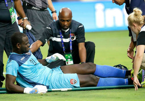 Photo: Trinidad and Tobago goalkeeper Jan-Michael Williams is helped on to the stretcher by physio Dave Isaacs during their 2015 Gold Cup fixture against Cuba. (Courtesy CONCACAF)