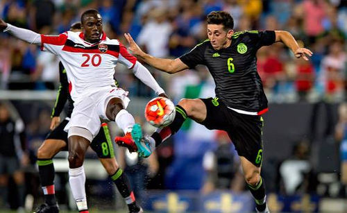 Photo: Trinidad and Tobago midfielder Keron Cummings (left) challenges Mexico midfielder Hector Herrera during 2015 CONCACAF Gold Cup action. (Courtesy CONCACAF)