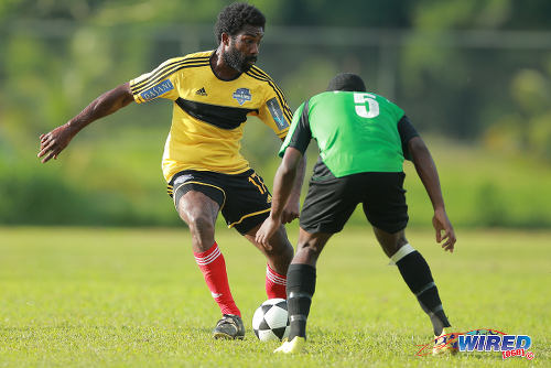 Photo: Cunupia FC striker Steve Stoute (left) takes on Prisons FC defender Sean Diaz during 2015 CNG National Super League Championship Division action at the Youth Training Facility, Arouca. (Courtesy Allan V Crane/Wired868