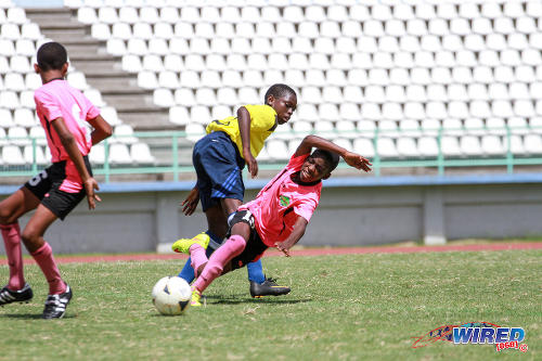 Photo: A San Juan Jabloteh player (right) loses his footing in the 2015 Republic Bank National Youth Cup Under-13 third place play off at the Larry Gomes Stadium in Malabar. (Courtesy Sinead Peters/Wired868)