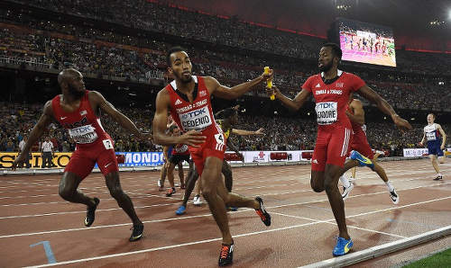 Photo: Trinidad and Tobago’s Machel Cedenio (centre) takes the baton from Deon Lendore in the final leg of the men’s 4x400 metres final at the 2015 IAAF World Championships at the “Bird’s Nest” National Stadium in Beijing on 30 August 30 2015. USA’s LaShawn Merritt (left) also receives the baton from Bryshon Nellum. (Copyright AFP 2015/ Franck Fife)