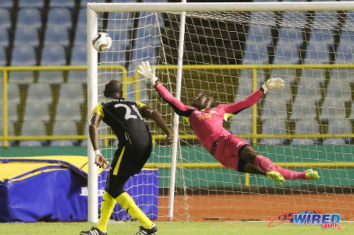 Photo: Defence Force FC goalkeeper Sheldon Clarke (right) dives in vain at an effort from St Ann's Rangers midfielder Miguel Romeo during 2015/16 Pro League action. Looking on is Defence Force left back Aklie Edwards. (Courtesy Chevaughn Christopher/Wired868)