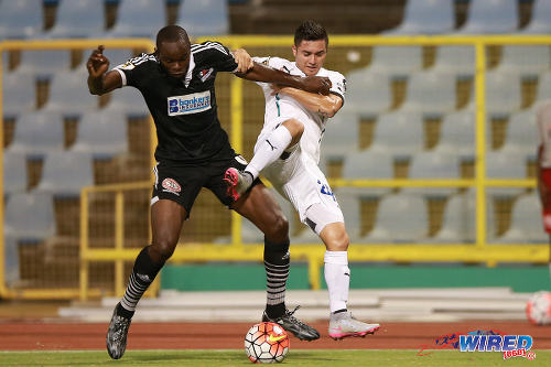 Photo: Central FC defender Andre Ettienne (left) brushes aside Comunicaciones attacker Carlos Figueroa during CONCACAF Champions League action at the Hasely Crawford Stadium, Port of Spain on 17 September 2015. (Courtesy Allan V Crane/Wired868)