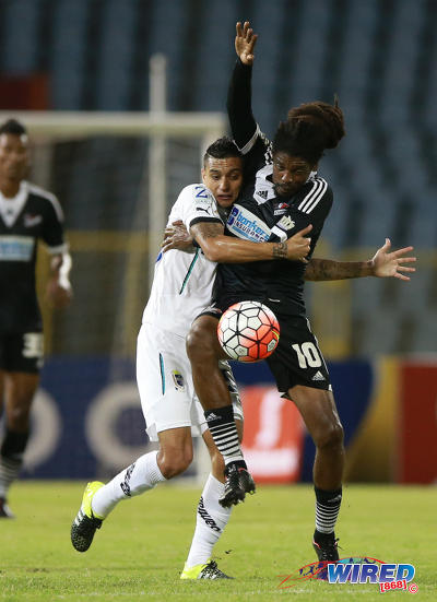 Photo: Comunicaciones midfielder Jorge Aparacio (left) grapples with Central FC star Marvin Oliver during 2015 CONCACAF Champions League action. (Courtesy Allan V Crane/Wired868)