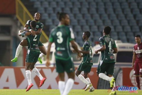 Photo: W Connection midfielder Jomal Williams (far left) jumps on top of teammate Kurt Frederick as they celebrate Frederick's opening goal against Deportivo Saprissa in 2015 CONCACAF Champions League action. (Courtesy Allan V Crane/Wired868)