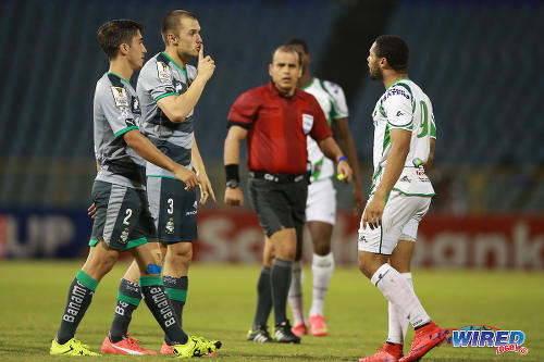 Photo: Santos Laguna defenders Kristian Alvarez (centre) and Javier Abella (left) gesture at W Connection attacker Shahdon Winchester (right) while referee Baldomero Toledo looks on during 2015 CONCACAF Champions League action at the Hasely Crawford Stadium, Port of Spain. (Courtesy Allan V Crane/Wired868)