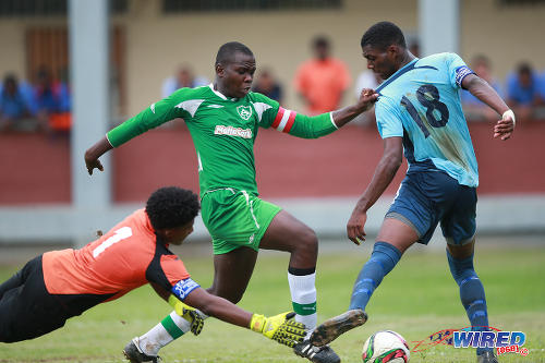 Photo: St Augustine captain Joshua Marshall (centre) tries to get to the ball between QRC goalkeeper Jardel Poon-Lewis (left) and defender Adrian Constantine during a 2015 SSFL contest. (Courtesy Allan V Crane/Wired868)